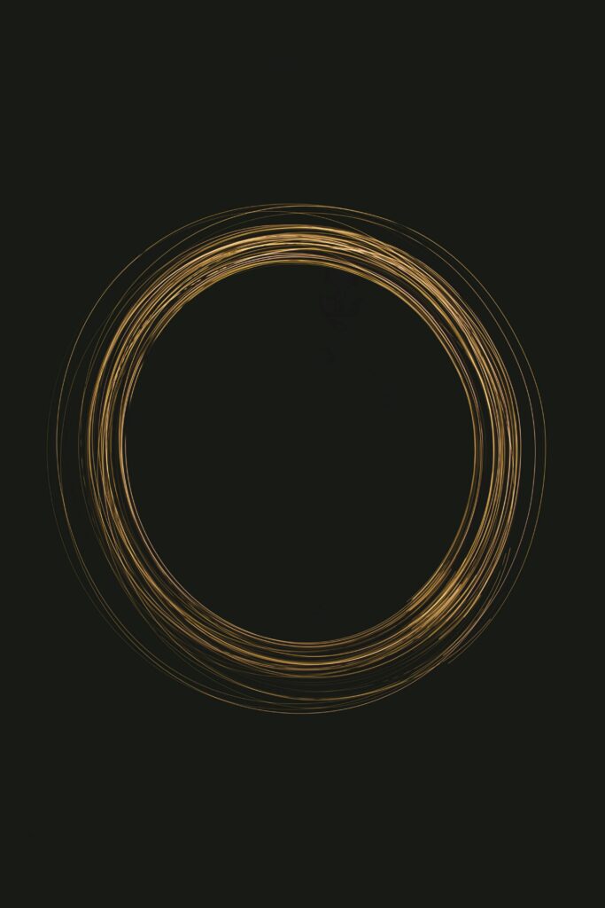 Abstract golden vortex circle on dark background, capturing light dynamics.